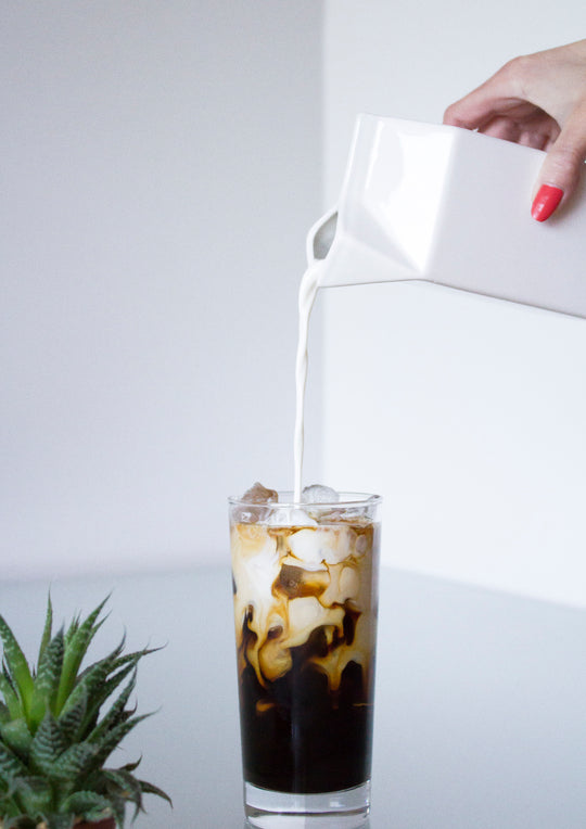 Frespi Iced Coffee With Girl In A Red Nails Pouring Milk On A White Background